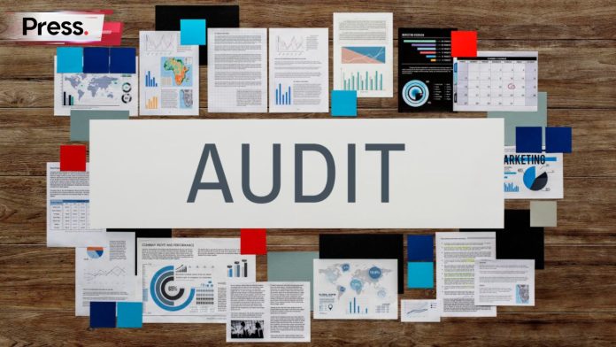 A pile of documents lying on a table, with the word 'Audit' in front of them, representing a keyword audit.