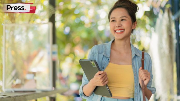 A female student at a private university in Malaysia, holding her tablet and bag.