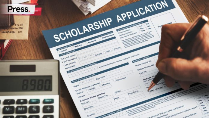 A person fills out a scholarship application form
